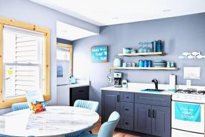 a kitchen with a table and a sink and a stove at Sea & Sun Cottage #3 in Hampton