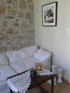 a living room with a white couch and a table at Stonebuilt boutique apartment Levanda in Kymi