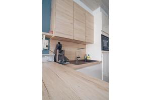 a kitchen with wooden cabinets and a counter top at Studiodevos in Middelkerke +3 photos