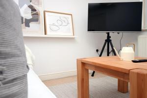 a living room with a television and a table at Alicia's House by Tŷ SA in Newport