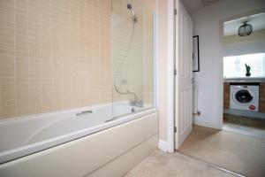 a bathroom with a bath tub and a shower at Alicia's House by Tŷ SA in Newport