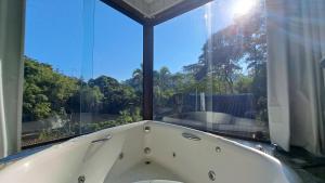 a bath tub in a room with a window at Pousada Valle dos Pássaros in Penedo