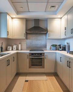 a kitchen with white cabinets and a stove top oven at The Burj View Suite Luxury 1BR Full Burj Views in Dubai