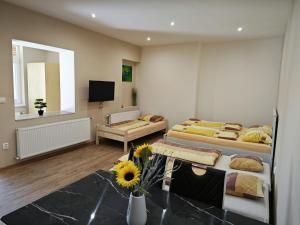 a room with two beds and a table with flowers in it at Mendi in Štúrovo