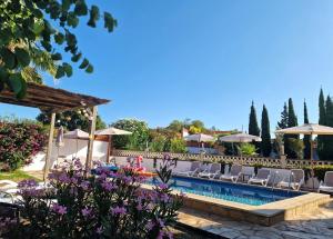 a pool at a resort with chairs and umbrellas at Villa de Gracia Casa 3 in Tordera