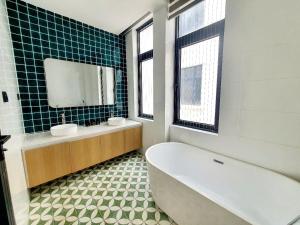 a bathroom with a tub and a sink and a mirror at AnDi's Homestay in Gò Công +18 photos