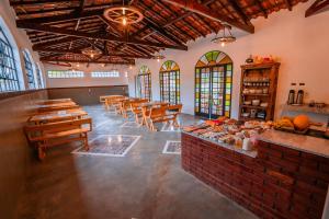 a restaurant with wooden tables and chairs and stained glass windows at Pousada Vale do Café in Bueno Brandão