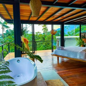 a bathroom with a bath tub and a bed at Suite Lodge En La Amazonía Con Actividades, Suite Kilo in Mera
