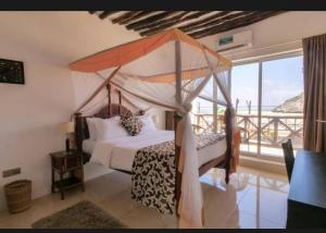 a bedroom with a canopy bed and a balcony at Isla Bonita Zanzibar Beach Resort in Matemwe +85 photos