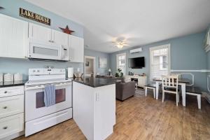 a kitchen with white appliances and a living room at The Catbird - 28 Butternut in Cherry Valley