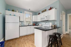 a kitchen with white cabinets and a white refrigerator at The Catbird - 28 Butternut in Cherry Valley