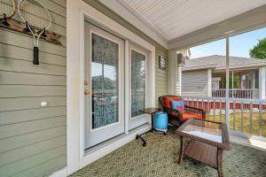 a porch with a chair and a table and a tennis racket at The Catbird - 28 Butternut in Cherry Valley