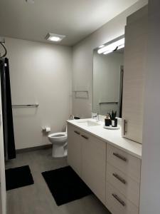 a bathroom with a toilet and a sink and a mirror at Modern 2 Bedroom with City and Water Views in Seattle +12 photos