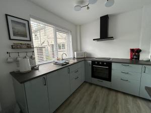 a kitchen with a sink and a stove top oven at The Wee Flat - Donaghadee in Donaghadee