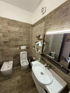 a bathroom with a white sink and a toilet at Coco Apartments in Vlorë