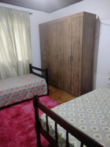 a bedroom with two beds and a cabinet at Casa de hospedagem in Blumenau