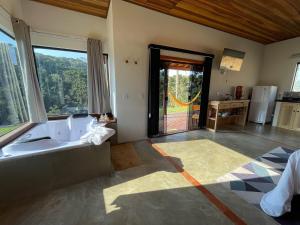 baño grande con bañera y ventana grande en Chalé Causo Bão, en Gonçalves