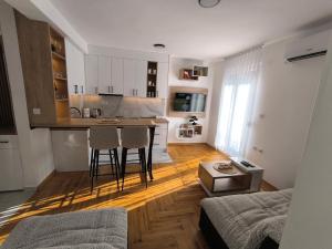 a kitchen with a table and chairs in a living room at Apartman Vujanac in Vrnjačka Banja +18 photos