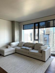 a living room with a couch and large windows at Modern 2 Bedroom with City and Water Views in Seattle