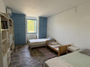 a small room with two beds and a window at Villa Loretta with pool, jacuzzi and garden in Posidhonía