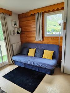 a blue couch in a room with a window at véritable 2 pièces, vue panoramique in Allos