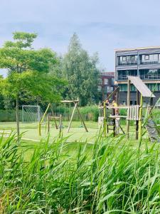 a park with a playground with two swings at B&Boatel Alibii in Alphen aan den Rijn +9 photos