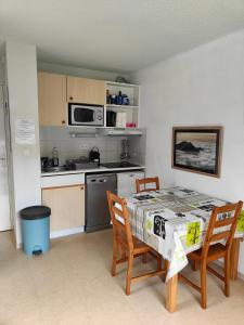 a kitchen with a table and two chairs and a microwave at véritable 2 pièces, vue panoramique in Allos