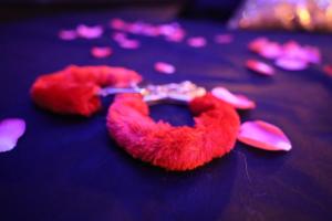 a red stuffed animal on a table with hearts at L Escapade Love Room in Laon