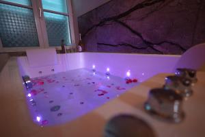 a bathroom with a sink with lights on it at L Escapade Love Room in Laon +28 photos
