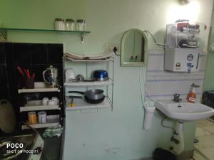 a small kitchen with a sink and shelves at Seabeach rest and nest in Puri