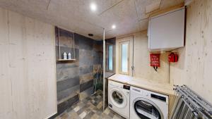 a laundry room with a washer and dryer in it at Havu Resort Laajavuori - Luksushuvila keskellä suomalaista metsää, Jyväskylä in Jyväskylä
