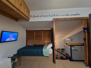 a bedroom with a bed and a tv on the wall at Orchidea Bianca in Giardini Naxos