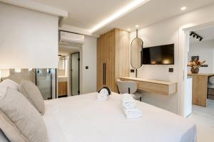 a bedroom with a white bed and a bathroom at Anar Luxury Villas in Kalamaki