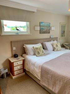 Un dormitorio con dos camas y una ventana. en Canterbury House, en Sidmouth