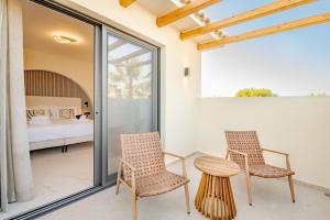 two chairs and a table in a room with a bed at Anar Luxury Villas in Kalamaki +54 photos
