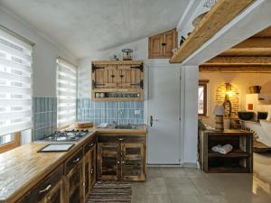 a kitchen with wooden cabinets and a sink and a stove at Doru' Bucovinei in Moldoviţa