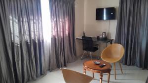 a room with a desk and chairs and a table and a desk with a computer at Dulelo Serowe in Serowe