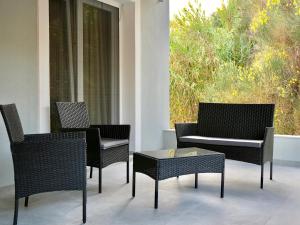 a group of chairs and a table on a patio at Anna's Corfu Escape Apartments 2 in Corfu