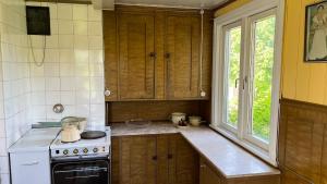 a kitchen with wooden cabinets and a stove and a window at Solbacka in Mysinge +40 photos