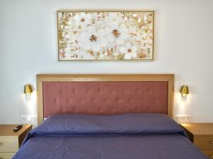 a bedroom with a bed with a picture on the wall at Anna's Corfu Escape Apartments 2 in Corfu