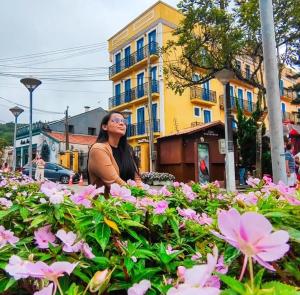 a woman sitting in a field of pink flowers at Itaúna in Guaramiranga