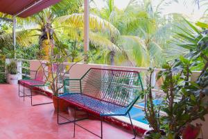 two benches sitting on a balcony with palm trees at Hotel Doña Mary Huatulco in Santa Cruz Huatulco