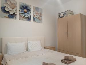 a bedroom with a bed and three paintings on the wall at Elina House 2 in Nikiti