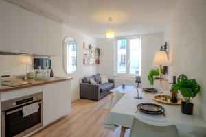a kitchen and a living room with a table in a room at Le Chativesle - Centre - Erlon in Reims