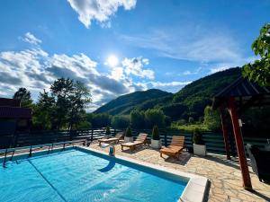 a swimming pool with chairs and a view of the mountains at Vikendica KaNo in Ždrijelo +21 photos