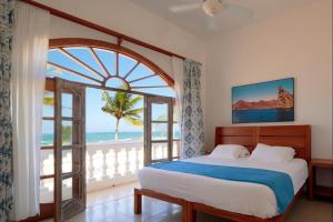 una camera da letto con un letto e una grande finestra di Hotel Albemarle Galapagos Beachfront a Puerto Villamil