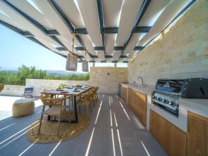 an outdoor kitchen with a table and a stove at Villa in Adele with Pool & Olive Grove Views in Ádhele
