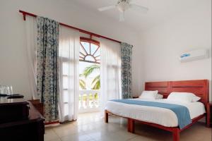 una camera da letto con un letto e una grande finestra di Hotel Albemarle Galapagos Beachfront a Puerto Villamil