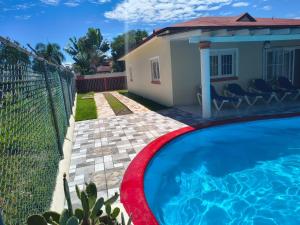 a house with a swimming pool and a fence at Apartamentos y Villas Michaela in Sosúa