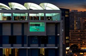 a building with a clock on the side of it at Best Western Premier Marina Las Condes in Santiago